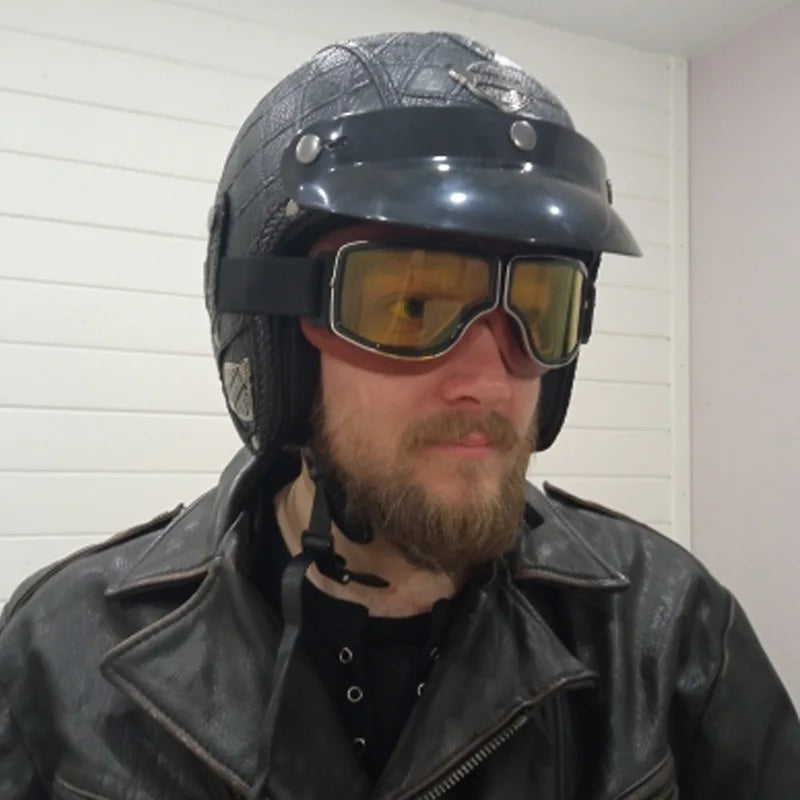 Retro motorcycle goggles with yellow lens worn with vintage helmet and leather jacket